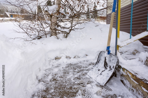 Shovel for clearing snow from the track, standing at the porch.