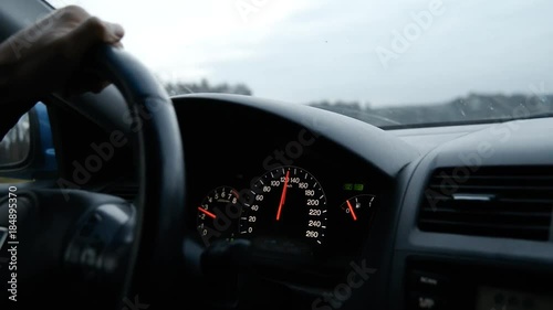 Look from inside of fast car man driving with 120 kmph on speedometr photo