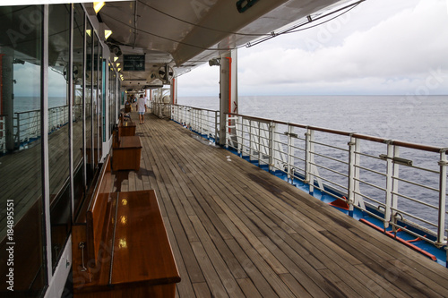 Teak lined Promenade Deck of modern cruise ship on a grey stormy day. © Philip Schubert