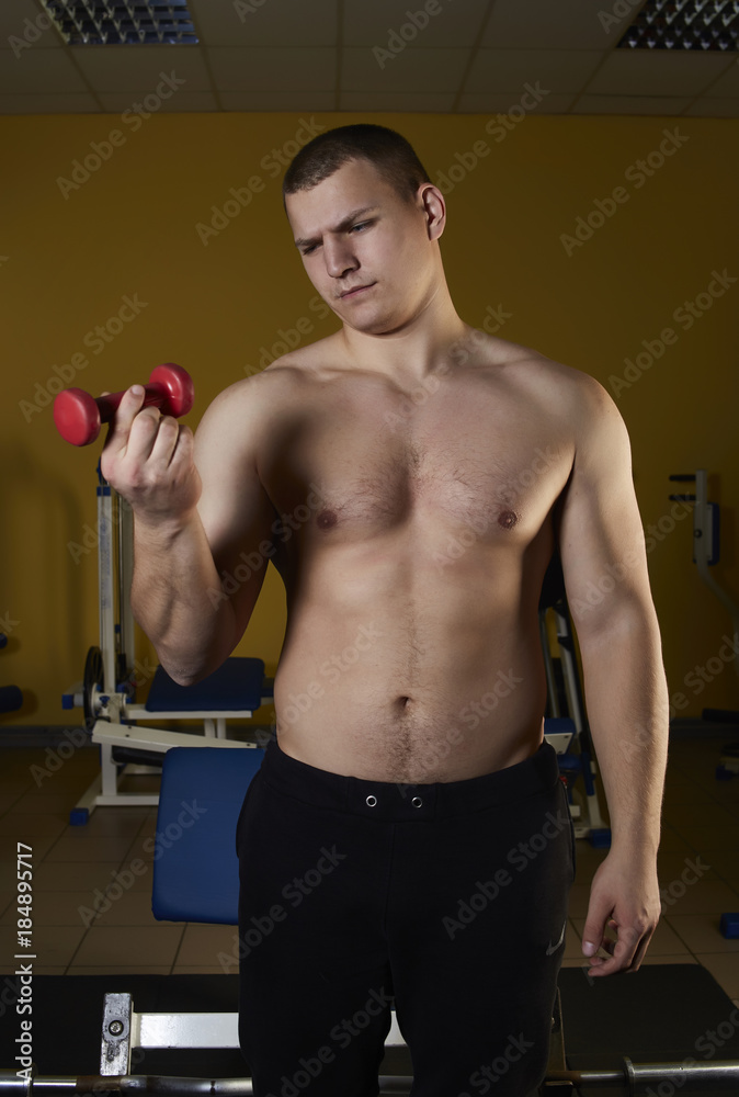 A young athlete is engaged on the simulator in the sports hall A young athlete is engaged on the simulator in the sports hall