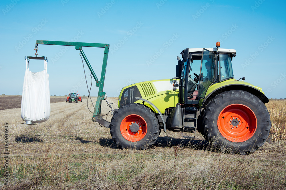 Modern tractor working in a field on a sunny day. Agricultural machinery during planting. Modern tractor working in a field on a sunny day. Agricultural machinery during planting.