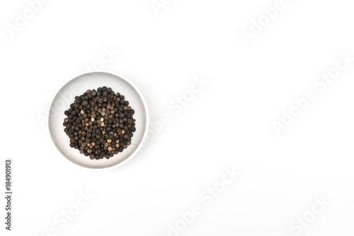 black pepper in a bowl on a colored background