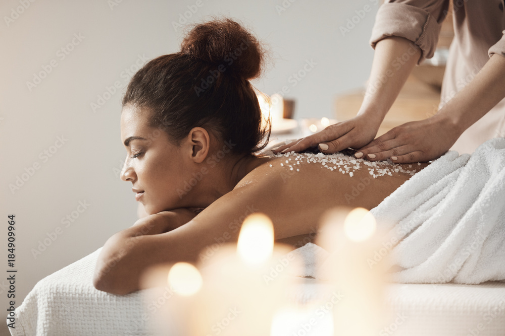 Fototapeta premium Beautiful african girl resting enjoying spa health massage with sea salt.