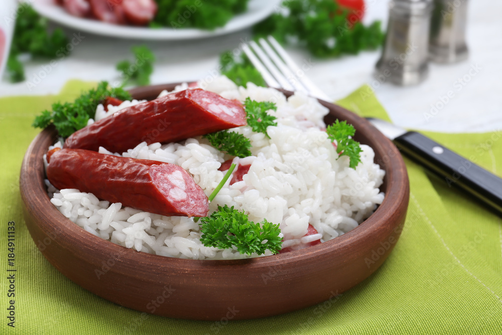 Wooden plate with rice and sausage on fabric Wooden plate with rice and sausage on fabric