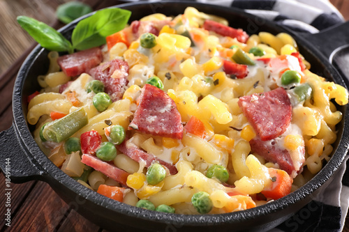 Pasta with sausage and vegetables in frying pan, closeup