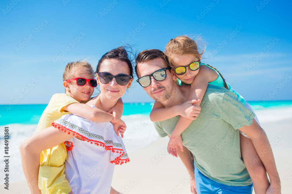Closeup happy family of four on beach vacation Closeup happy family of four on beach vacation