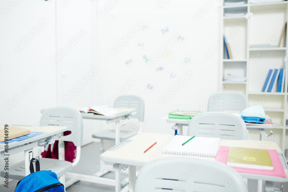 Empty modern classroom without schoolchildren by desks during break Empty modern classroom without schoolchildren by desks during break