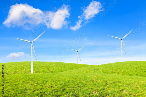 Several windmills on grassy hills under beautiful sky. Windmills alternative energy source, environment protection