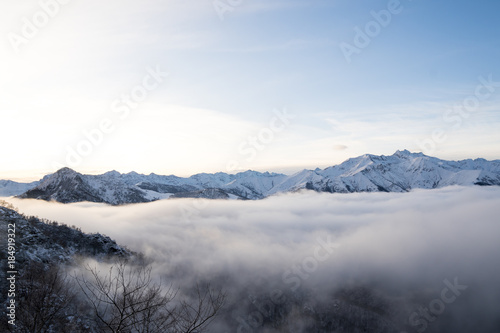 Winter panorama of Italian Alps with snow and fog