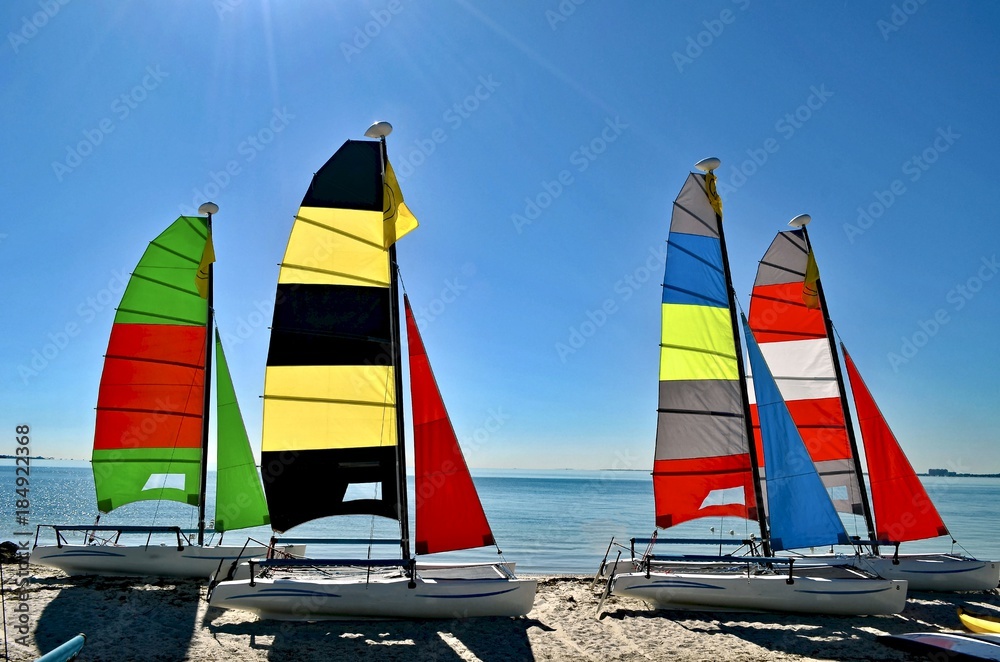 Obraz premium Small sailing catamarans resting in the sand on a beach on Key Biscayne ,Florida