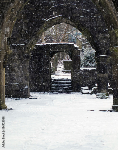 ruined church in snowfall with doorway and arches in heptonstall west yorkshire