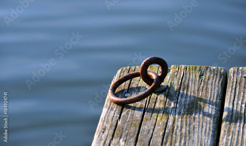 wooden dock with metal ring in water 