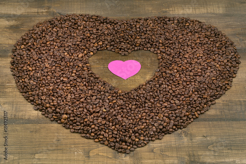 Heart of coffee beans on a wooden surface © Denis