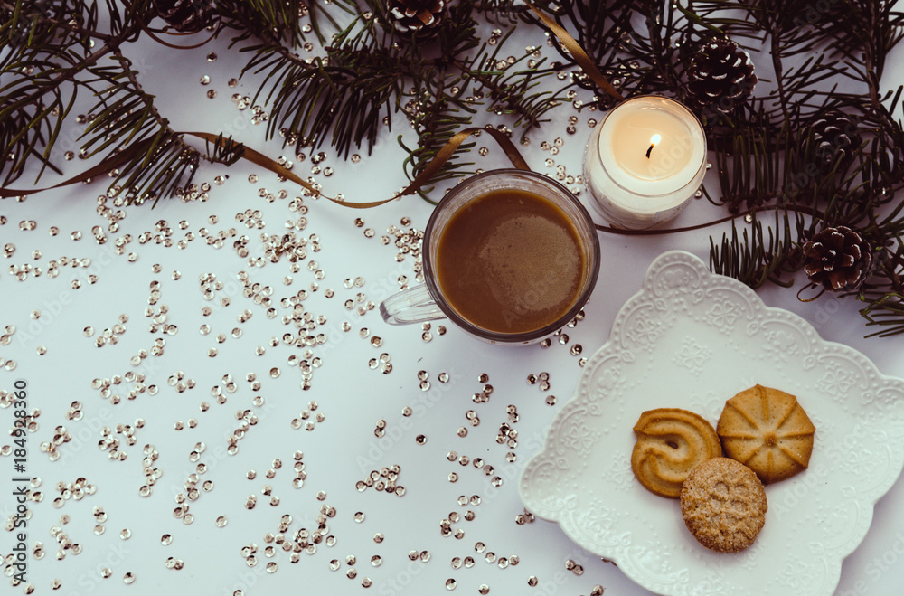 Cup of coffee, candle and cookies on table with winter decorations. Top view. Cup of coffee, candle and cookies on table with winter decorations. Top view.