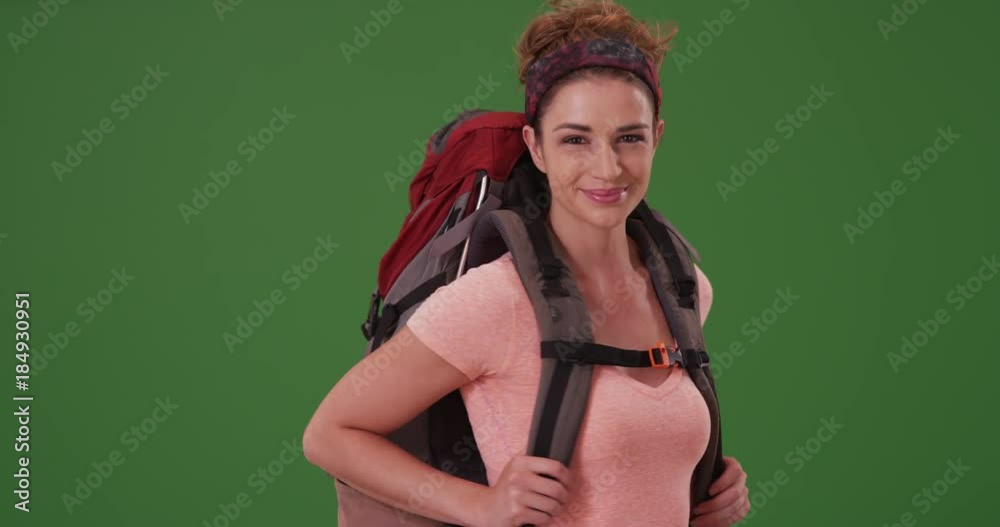 Young woman in her 20s travelling the world on green screen. On green screen to be keyed or composited. 