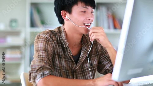 young asian man chatting online with computer