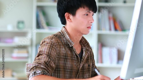 young asian man using computer indoor