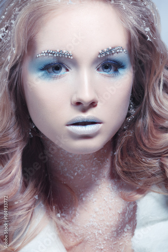Beauty portrait of a beautiful blonde girl with a creative make-up of a snow queen.