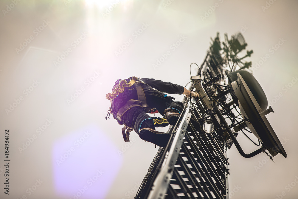 Telecom Worker Climbing Antenna Tower with Harness and Tools - obrazy, fototapety, plakaty 