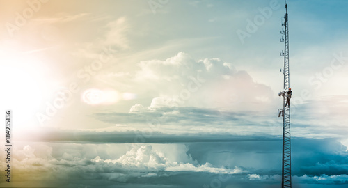 Telecom Worker Climbing Antenna Tower with Harness and Tools