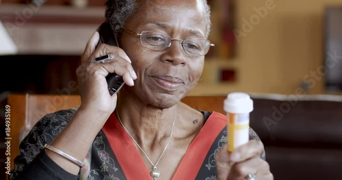 Black senior woman refilling her prescription on a cordless landline phone