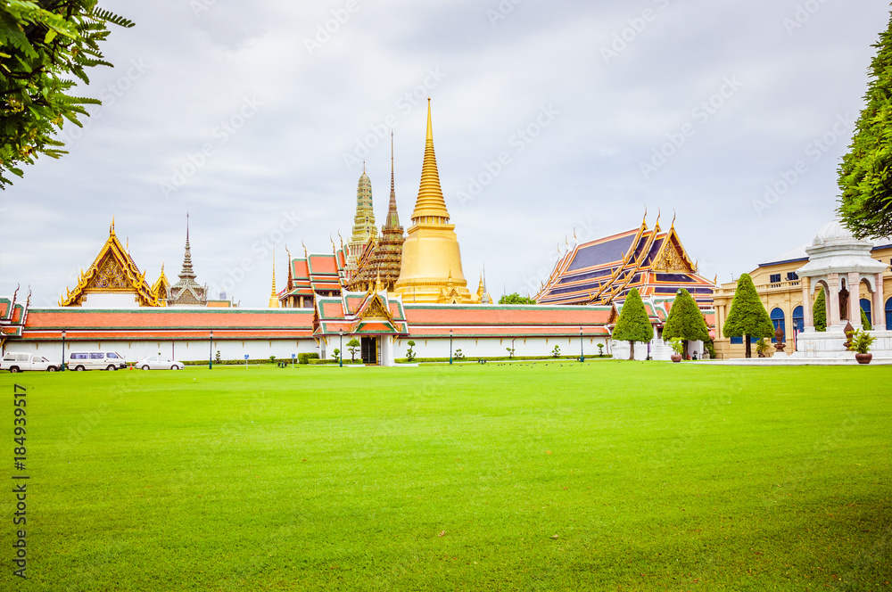 Naklejka premium Royal palace in Bangkok, green grass and grey sky on the background