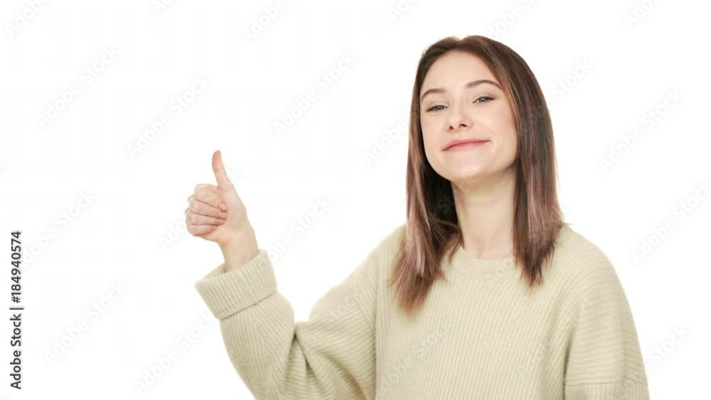 Half-turned portrait of friendly adult woman looking at camera with smile showing thumb up meaning good choice or agreement over white background copy space. Concept of emotions Half-turned portrait of friendly adult woman looking at camera with smile showing thumb up meaning good choice or agreement over white background copy space. Concept of emotions