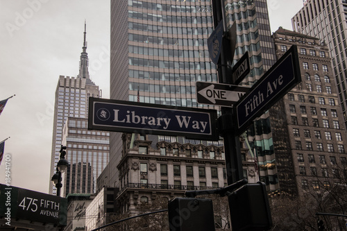 Multiple directional signs on a light post in New York City photo