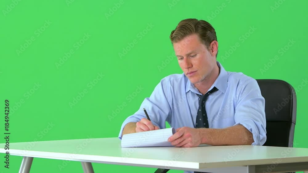confident businessman sitting at his desk on greenscreen