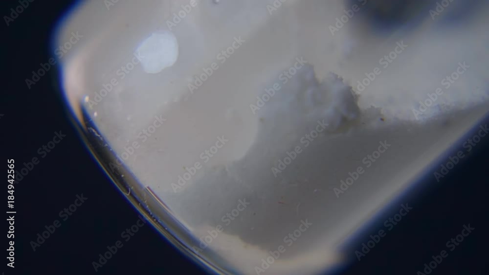 Syringe needle pierces the rubber stopper of the glass vial and diluted from saline the crystals of the medicament. Closeup. Slow motion, slo mo, high speed camera, 240fps, 250fps Syringe needle pierces the rubber stopper of the glass vial and diluted from saline the crystals of the medicament. Closeup. Slow motion, slo mo, high speed camera, 240fps, 250fps