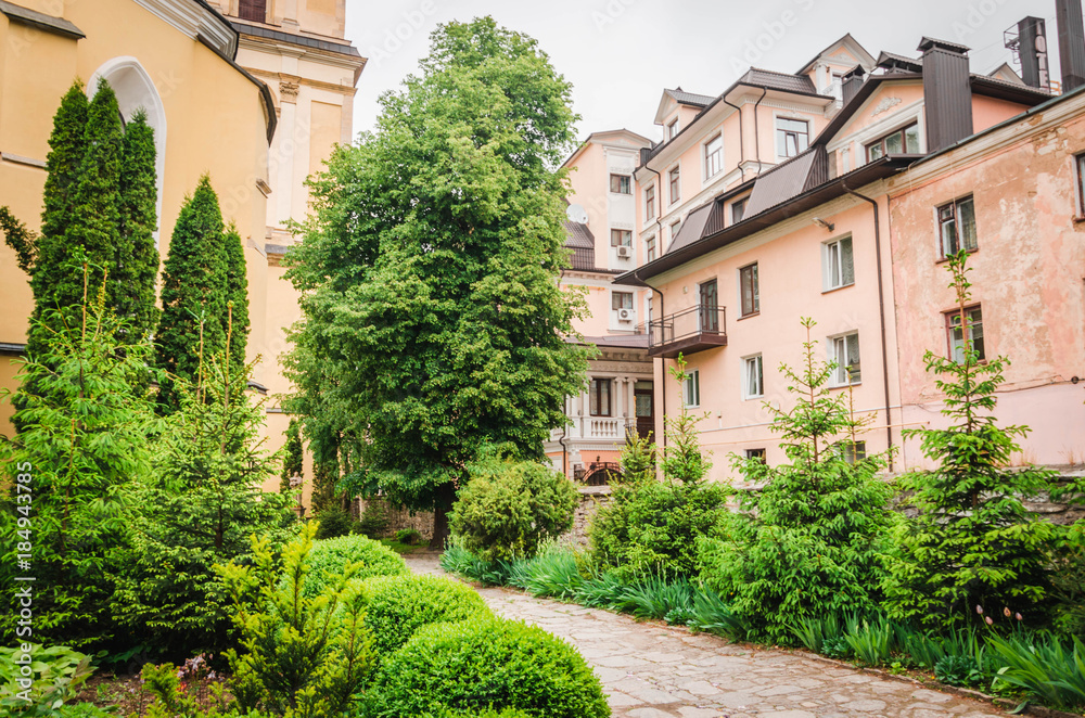 Path crossing flowered yard with people and old building in the Garden of Plants in Paris Path crossing flowered yard with people and old building in the Garden of Plants in Paris