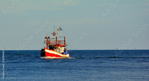 One fisherman boat in a sea blue sky background