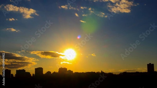 Wallpaper Mural Lovely time lapse of sunset, with golden sun, with gray-white clouds, with azure sky, with lense flares, against the background of the city silhouette. The camera approach very fast Torontodigital.ca
