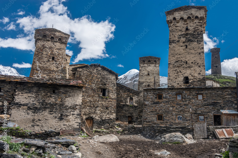 Medieval stone towers in the background of mountains and blue sky. Medieval stone towers in the background of mountains and blue sky.
