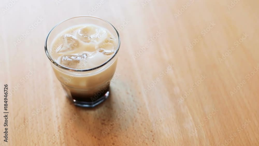 View of coffee with syrup and ice cubes on a table View of coffee with syrup and ice cubes on a table