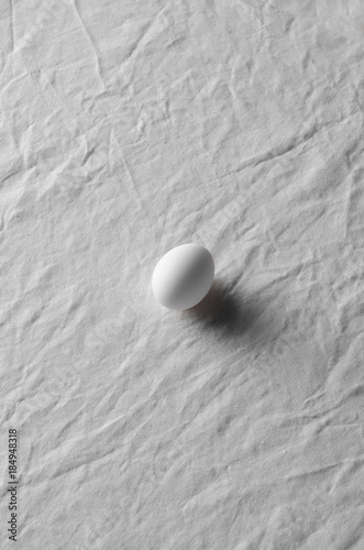 White eggs on a white linen tablecloth background.