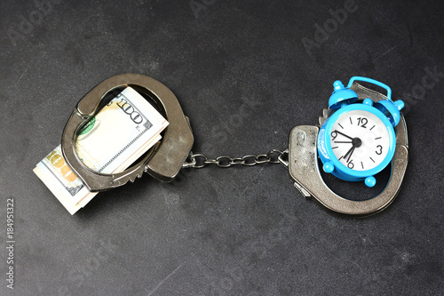 Foto Handcuffs, money and alarm clock on dark background, bail concept