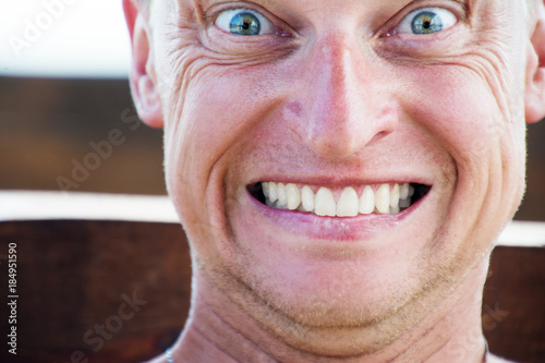 Close up portrait of funny man, grins his teeth