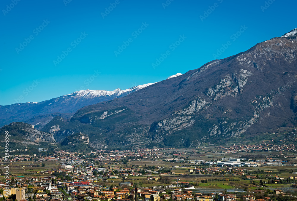 Beautiful panoramic view on the snowy mountains near Lake Garda and Arco Castle, Italy