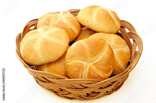 Fresh baked rolls in a basket on white