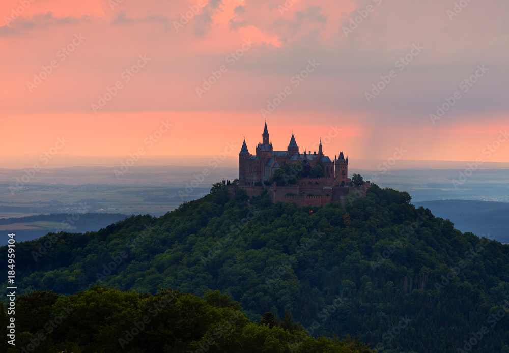 German Castle Burg Hohenzollern over the clouds at sunset landscape