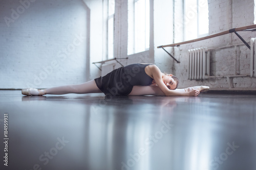 Young ballet dancer practice twine stretching in studio active lifestyle photo