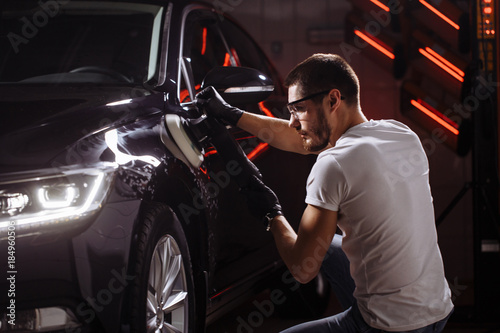 Car polish wax. worker hands holding a polisher and polish car photo