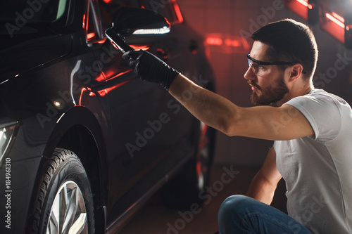 man checks the polishing with a torch