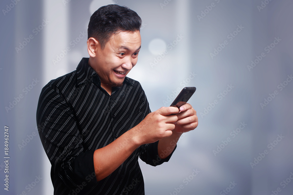 Young Man Texting Reading Chatting on His Phone, Smiling Happy Young Man Texting Reading Chatting on His Phone, Smiling Happy