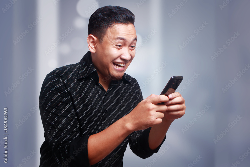 Young Man Texting Reading Chatting on His Phone, Smiling Happy Young Man Texting Reading Chatting on His Phone, Smiling Happy