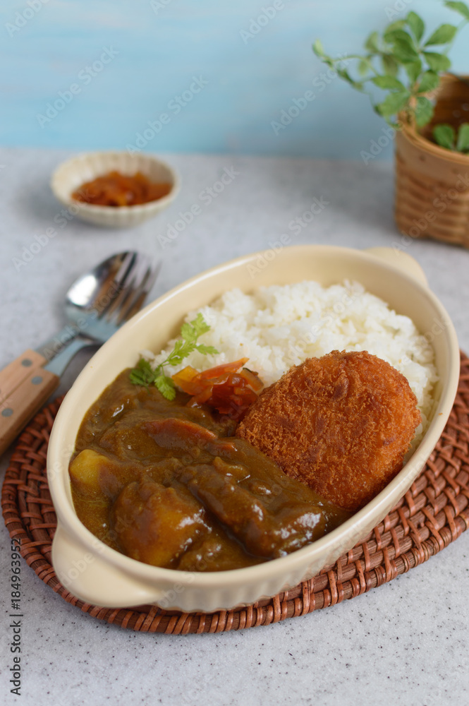 a plate of Japanese curry rice accompanied with breaded fried potato a plate of Japanese curry rice accompanied with breaded fried potato