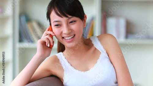 pretty young asian woman talking on the phone indoor