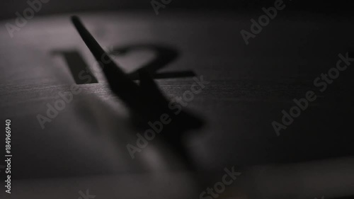 Camera moves to see clock hands ticking close to 12 o clock