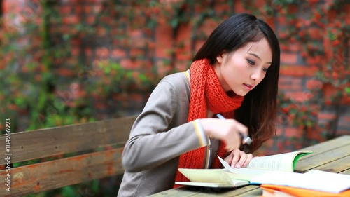 pretty college student reading book in the campus